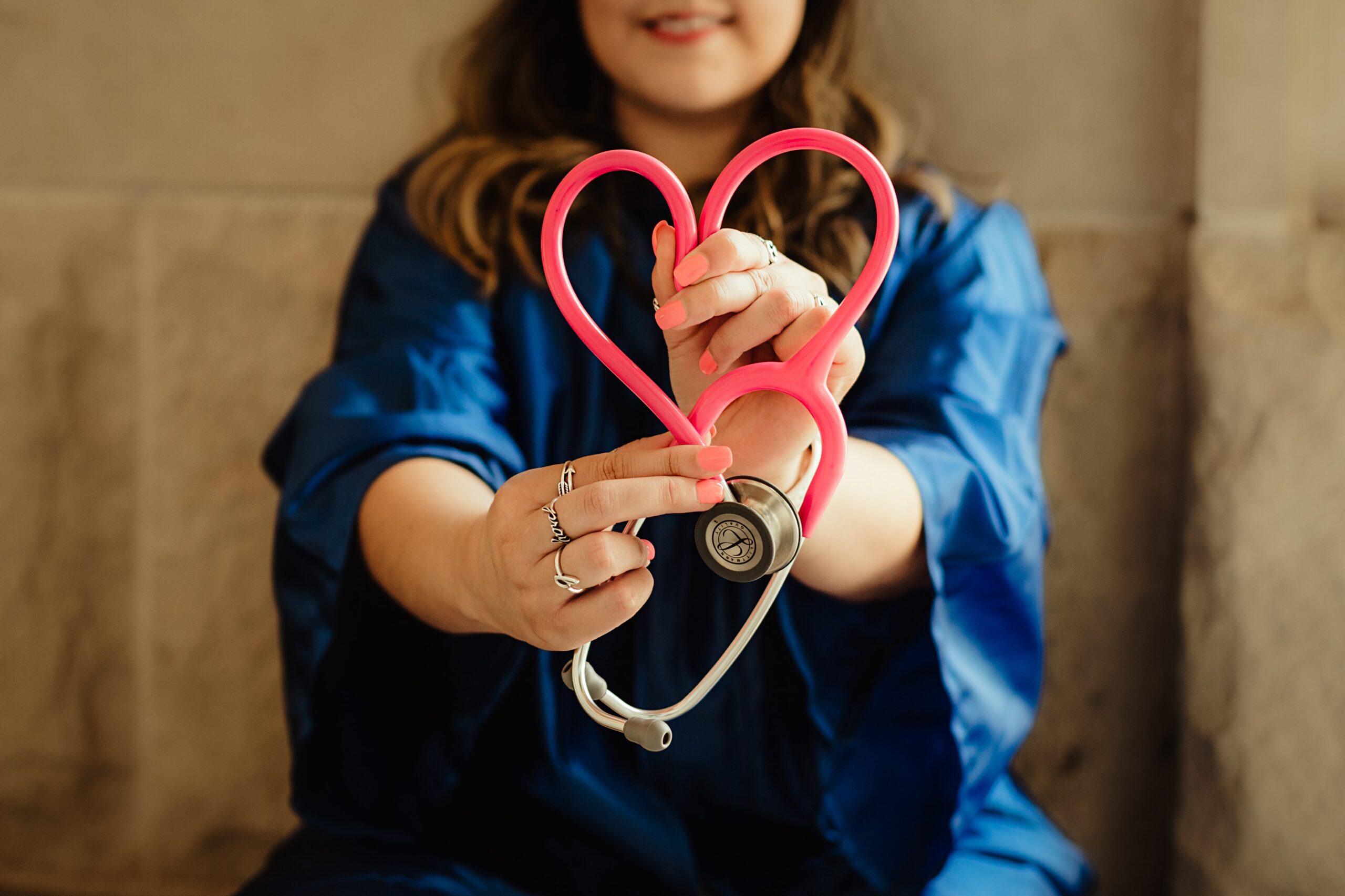 woman holding stethoscope in the shape of a heart